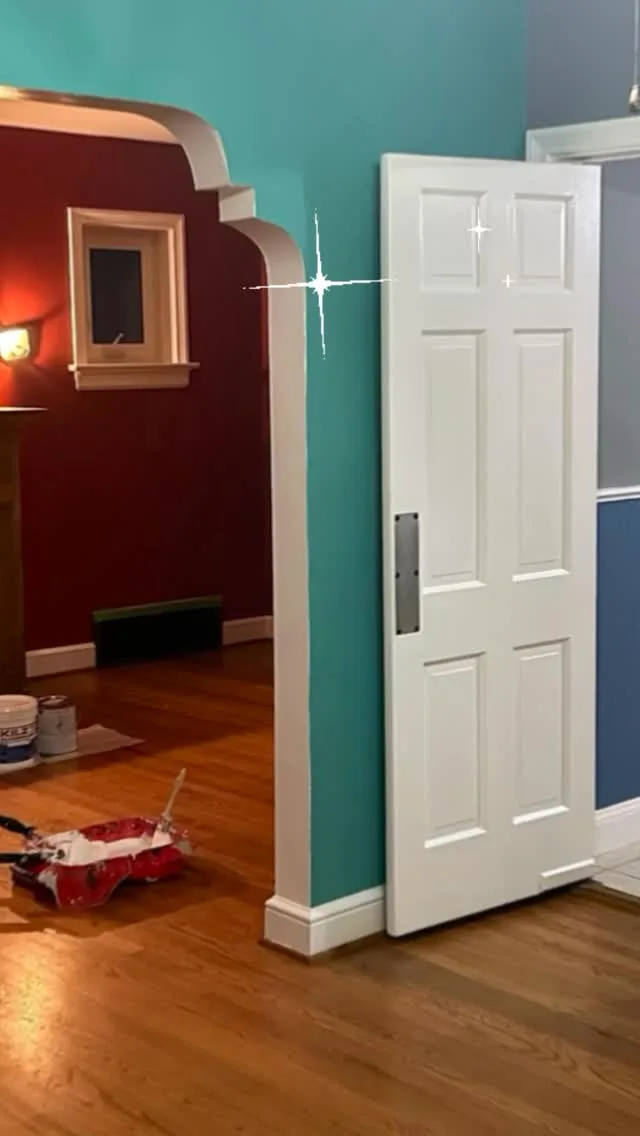 Burgundy walls with a white six-panel door and trim