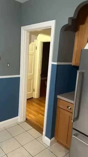 Two-tone hallway with a blue lower wall and white chair rail